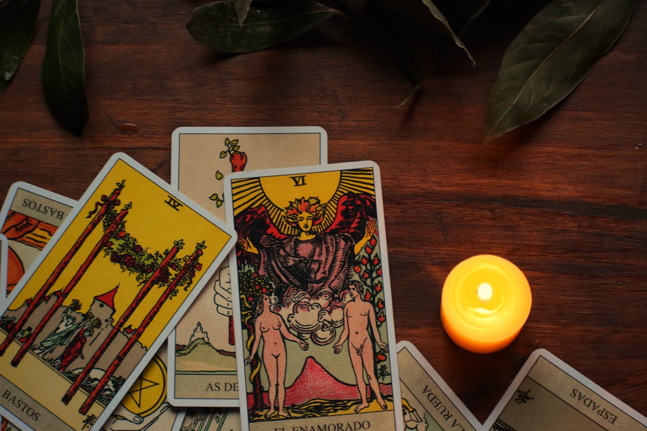 A mystical arrangement of tarot cards with a burning candle creates an ambiance for fortune telling.